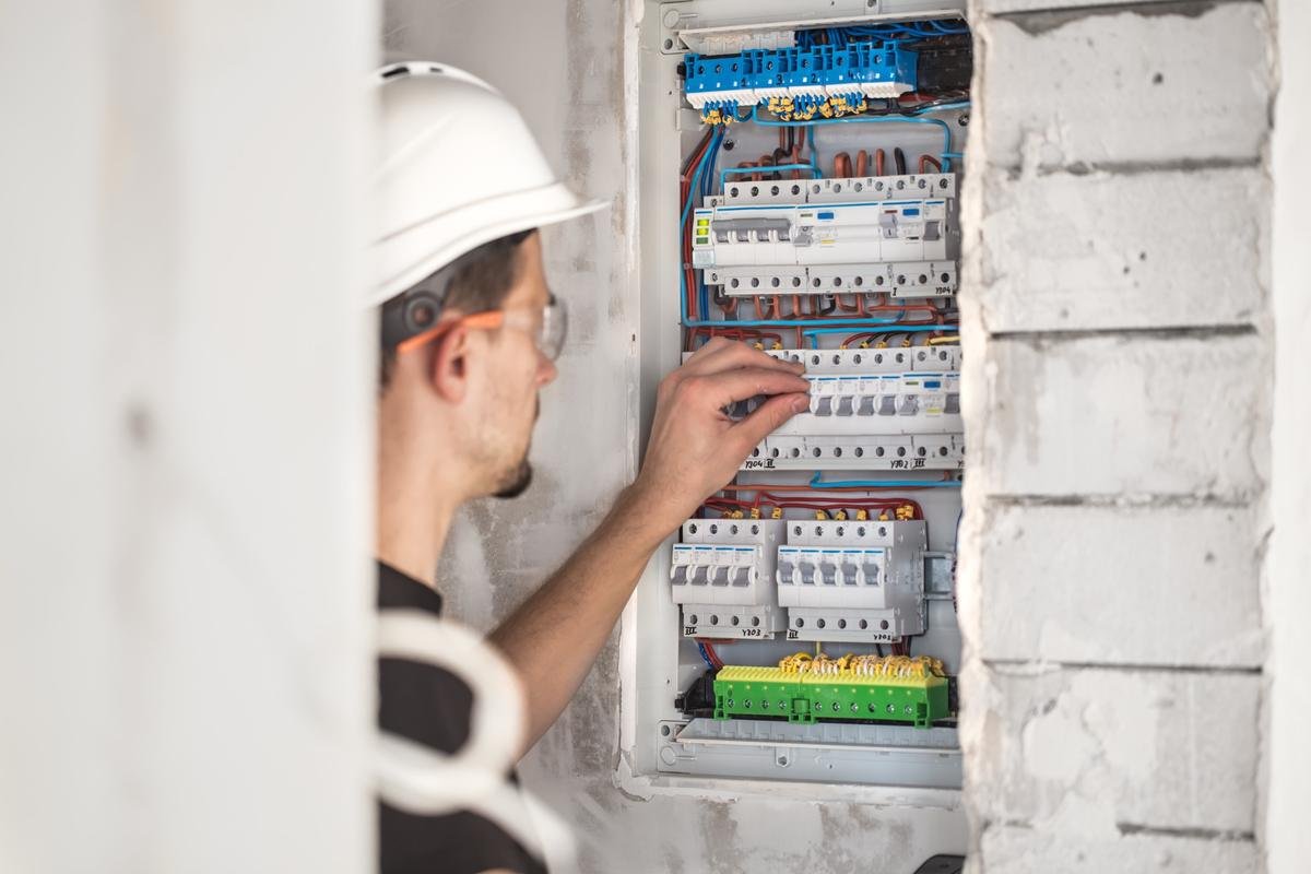 man-electrical-technician-working-switchboard-with-fuses-installation-connection-electrical-equipment